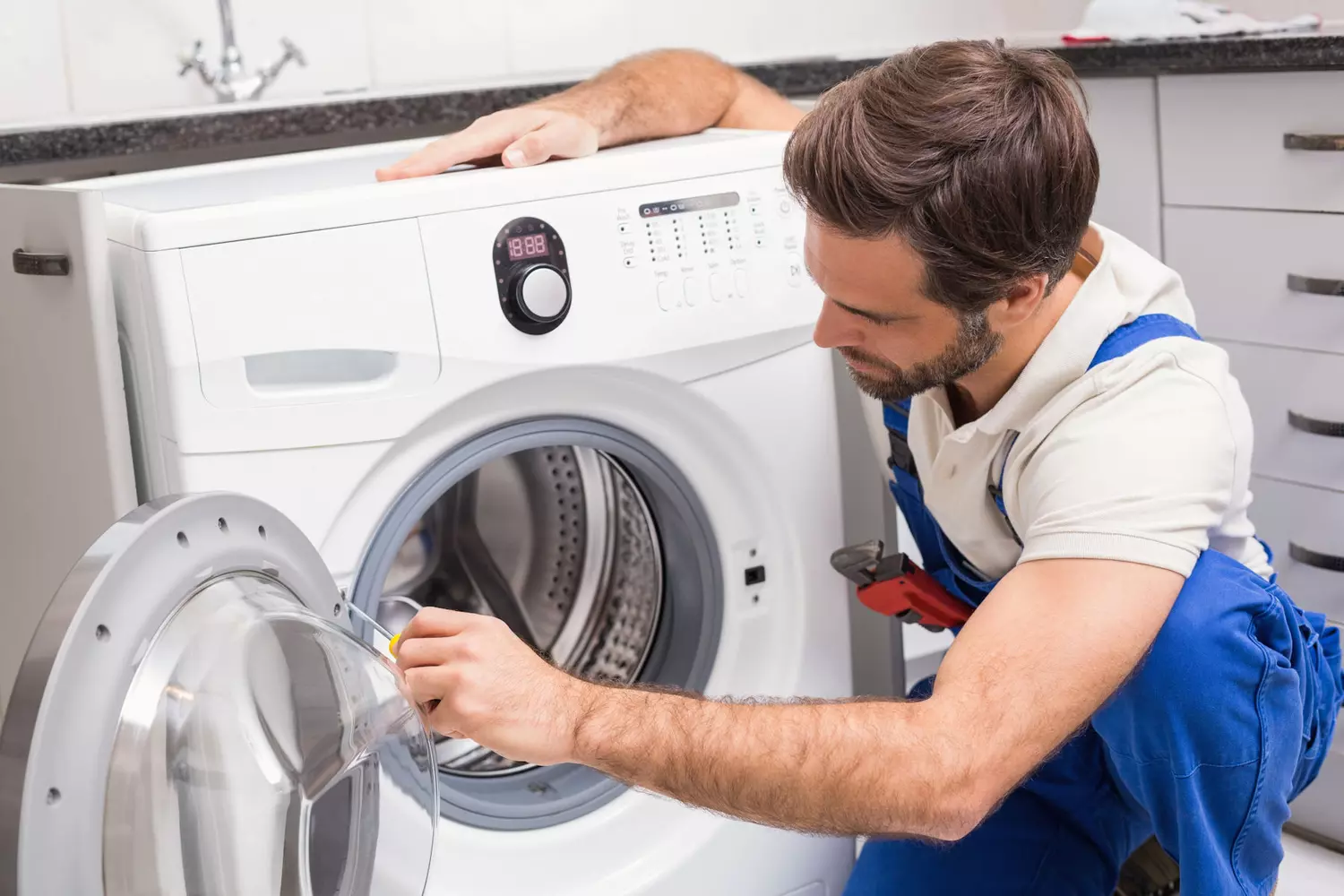 Technicien qui répare un lave-linge