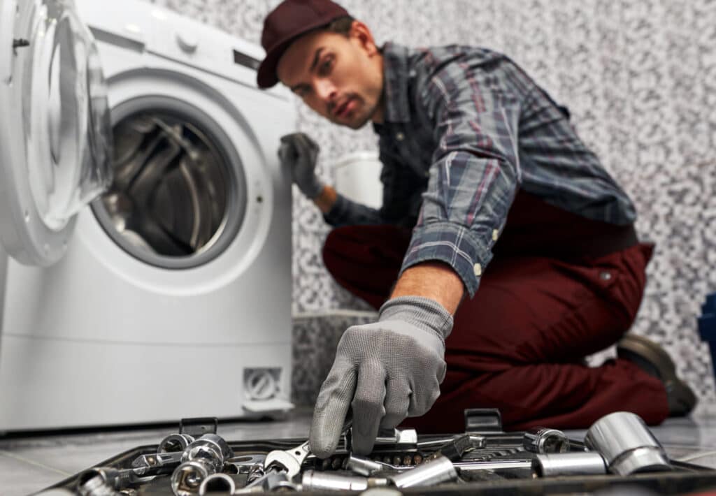 Technicien qui répare un lave-linge