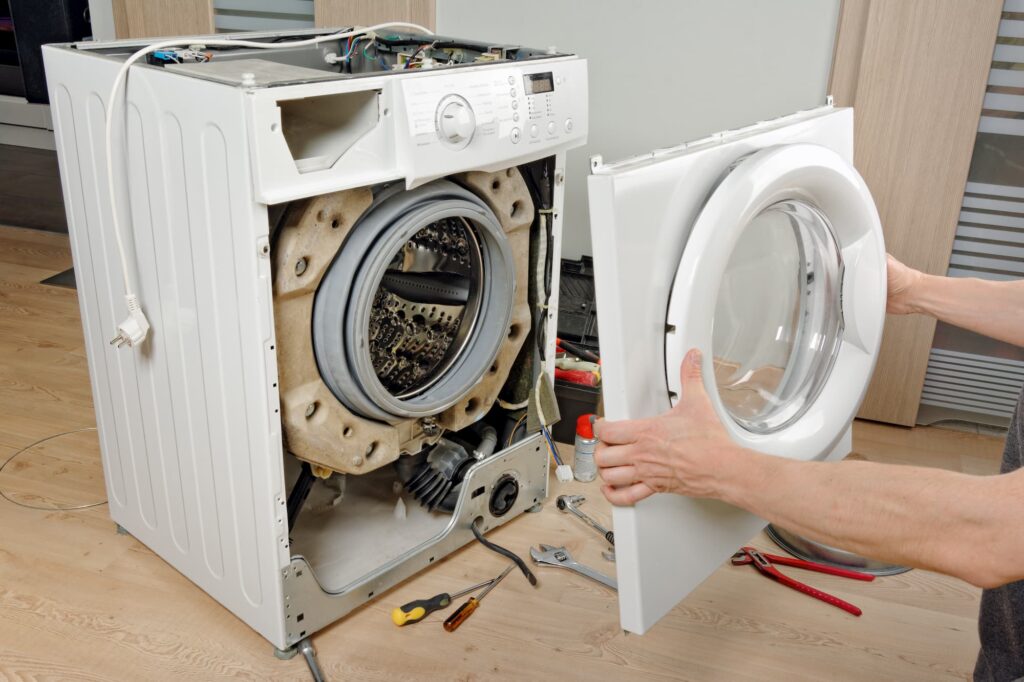 Technicien qui répare une machine à laver